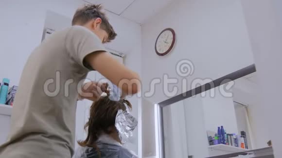 专业男理发师在工作室给女客户染发视频的预览图