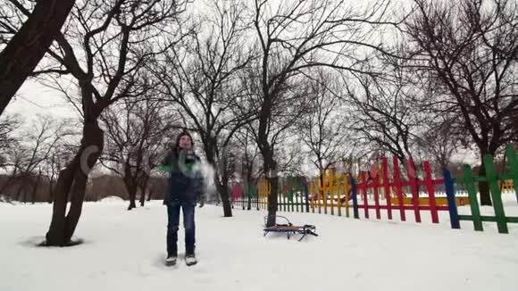 高清开朗的男孩正在公园的雪地里玩耍视频的预览图