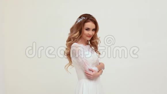 美丽的姑娘新娘穿着婚纱摆着笑白脸视频的预览图