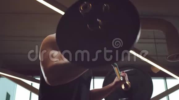运动英俊的男性运动员在健身房工作使用杠铃强壮健康的健美腹部训练视频的预览图