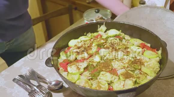 男性厨师的手在大锅中混合煮熟的蔬菜视频的预览图