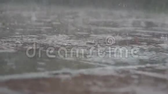雨继续在铺路板和水坑上视频的预览图