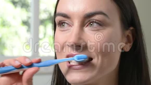 卫生间用手工牙刷刷牙的女人视频的预览图