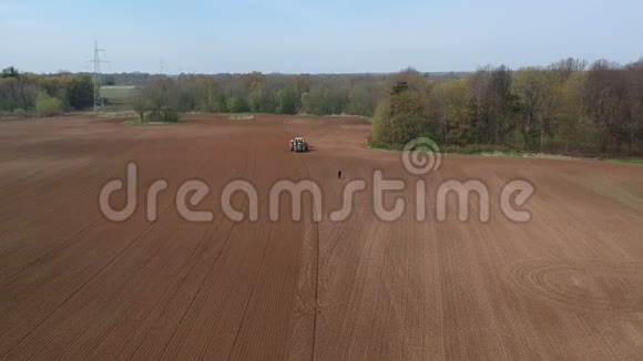 拖拉机在美丽的春田上播种空中视频的预览图