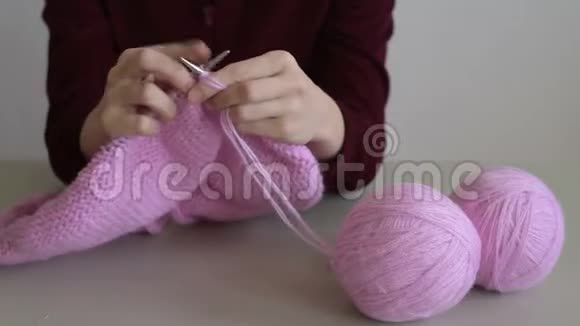 女人织一件粉红色的毛衣视频的预览图