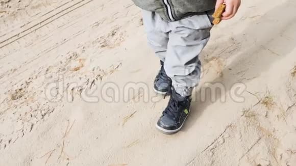 一个小男孩正沿着沙子走视频的预览图