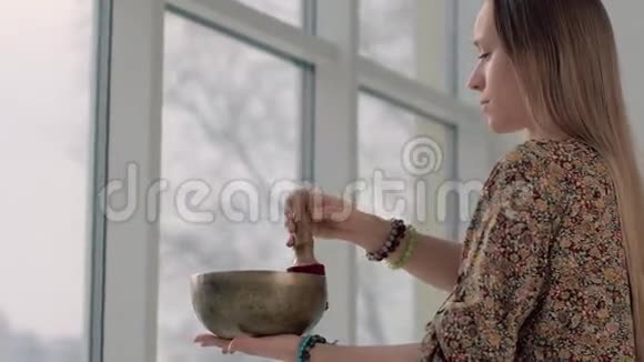 年轻的瑜伽女人用唱歌碗放松视频的预览图
