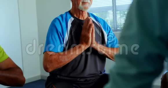 积极的高加索老人在4k健身室做瑜伽的正面景色视频的预览图
