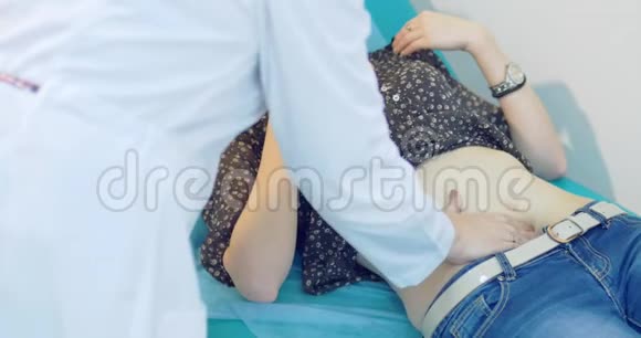 医疗中心腹部触诊医生手握女病人视频的预览图