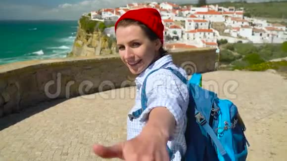 跟我来一个快乐的年轻女人她戴着红帽子背着背包拉着一个男人他的手在玛尔的阿岑哈视频的预览图