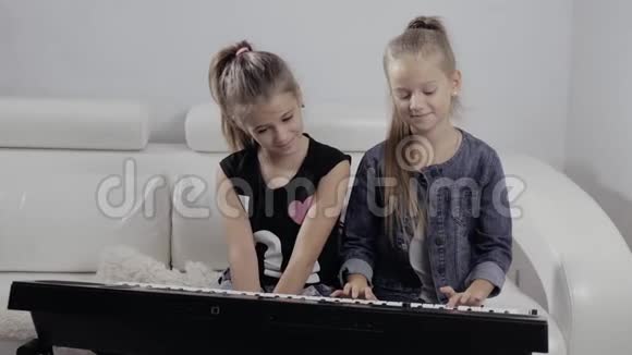 两个小女孩在家弹钢琴快乐的朋友视频的预览图