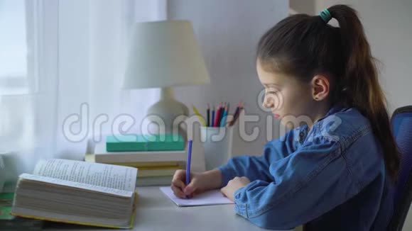 可爱的小女孩在桌子上做作业视频的预览图