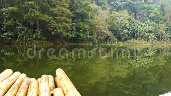 南有竹筏的高山针叶热带森林在高原湖泊平静的水中倒影视频的预览图