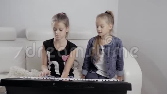 两个小女孩在家弹钢琴快乐的朋友视频的预览图