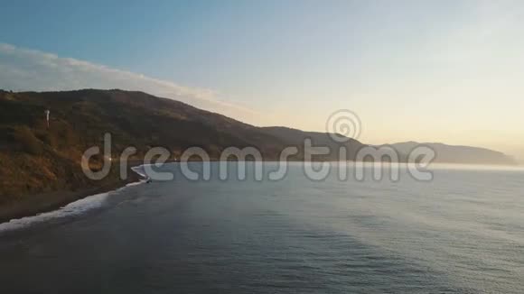 日出时升起在海岸和山脉之上空中无人机在黑海海岸拍摄了美丽的早晨视频的预览图