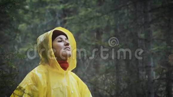 女孩在雨中严肃雨落了水滴落在他的脸上女孩对周围的生活和自然感到高兴视频的预览图