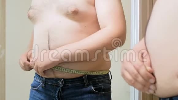 4k片年轻人用卷尺测量他的大肚子视频的预览图