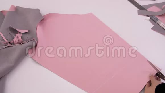 裁缝裁剪布料工作中的裁缝从粉红色的布料上缝一件运动衫车间进行服装裁剪设计视频的预览图