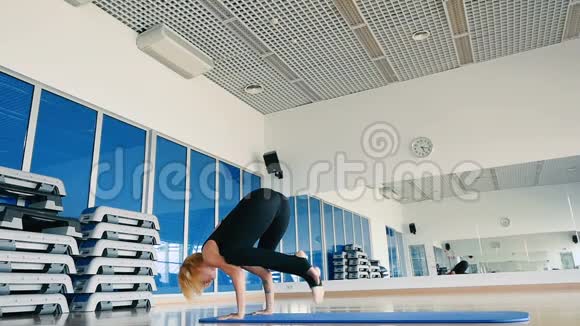 慢动作年轻女孩在运动中心练习瑜伽视频的预览图