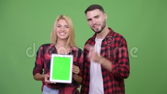 年轻夫妇一起展示数字平板电脑竖起大拇指视频的预览图