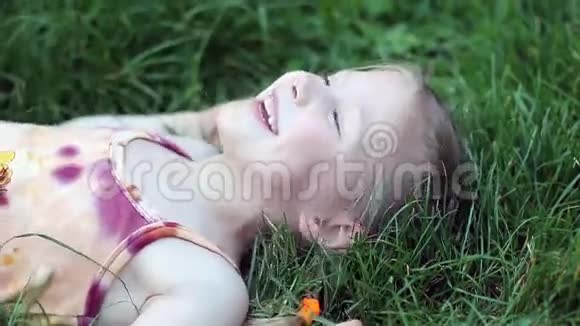 躺在草地上笑的女孩视频的预览图