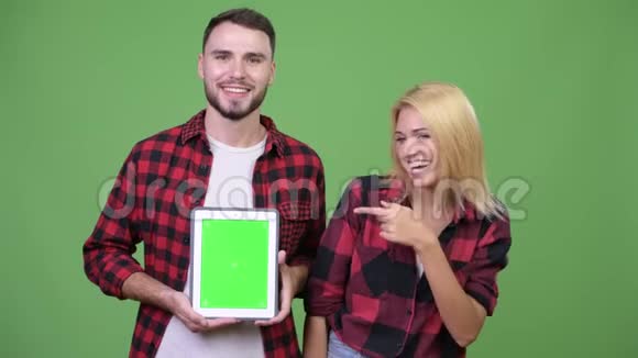 年轻夫妇一起展示数字平板电脑竖起大拇指视频的预览图