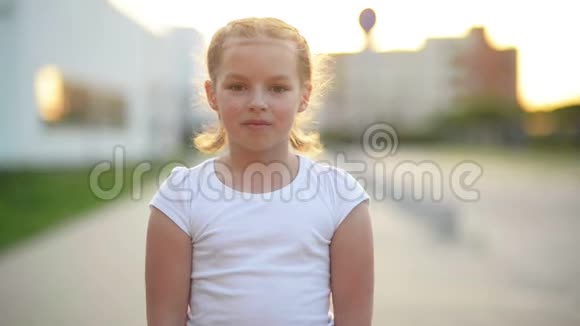 欧洲金发小女孩用牙齿微笑的特写肖像阳光明媚的下午让快乐的孩子变得快乐视频的预览图