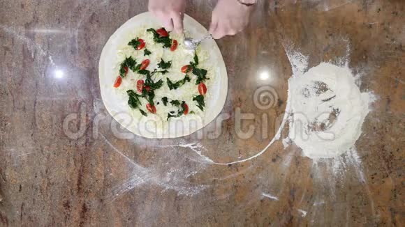 厨师在厨房里把配料放在比萨饼上披萨概念食品的生产和运送顶部视频的预览图