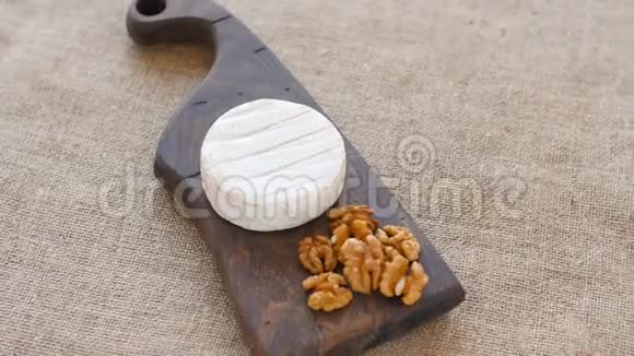 白色霉菌奶酪在木切割板上旋转视频的预览图