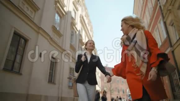 两个女朋友在城市里走来走去笑着慢动作地拥抱着视频的预览图
