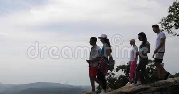 山顶游客群人们在手机上拍照欣赏日出景观视频的预览图