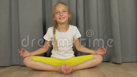 年轻女孩坐在禅宗的姿势和做冥想白姑娘在家客厅练瑜伽视频的预览图