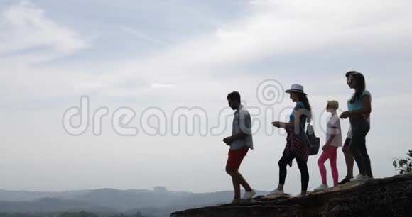 山顶游客群人们在手机上拍照欣赏日出景观视频的预览图