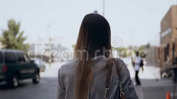 在阳光明媚的日子里年轻的黑发女人穿过纽约繁忙的市中心慢动作视频的预览图