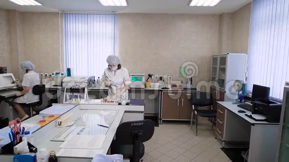 在实验室工作的专家穿白色制服的女性在临床实验室进行分析视频的预览图
