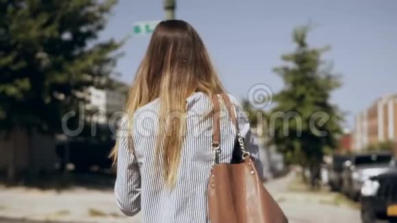 在阳光明媚的日子里年轻的黑发女人穿过纽约的市中心慢动作视频的预览图