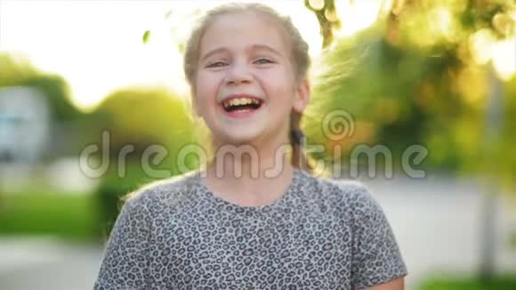 一幅欧洲金发女孩的特写肖像她的牙齿都在微笑阳光明媚的下午快乐的孩子造就了视频的预览图
