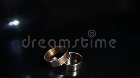 婚礼戒指黑色背景闪耀与轻珠宝关闭宏两个新娘和新郎的魅力戒指视频的预览图