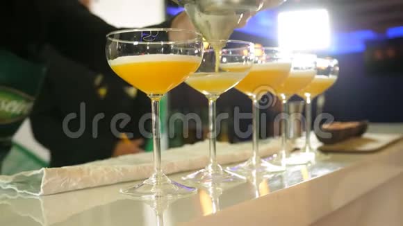 从柑橘和芒果汁中提取5种鸡尾酒的过程中酒保拿着摇瓶倒出视频的预览图