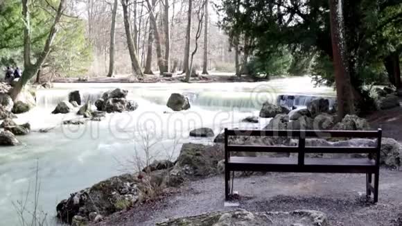 德国慕尼黑一条河前英国花园里的一条独立长凳视频的预览图