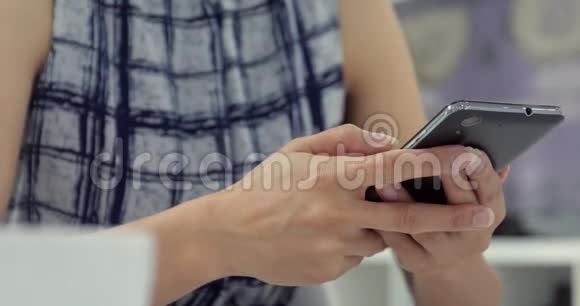 亚洲女人在家里用智能手机打短信视频的预览图