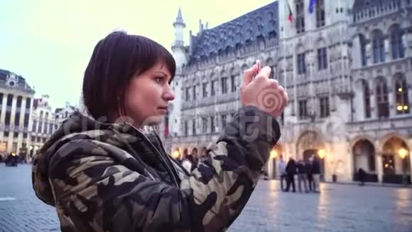 女游客在比利时布鲁塞尔的大广场上拍照视频的预览图