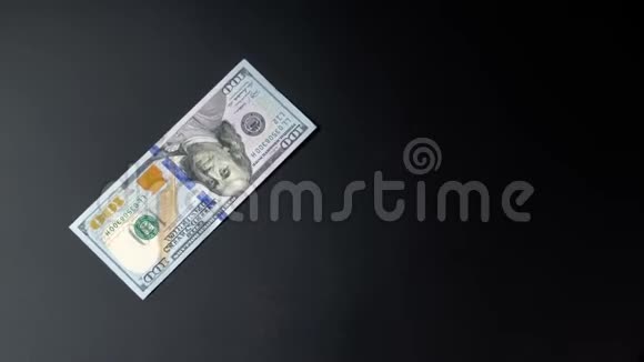 绿色美元或美元正在黑色背景特写上慢慢旋转视频的预览图