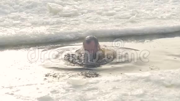 一个人从冰洞里的冷水中出来视频的预览图