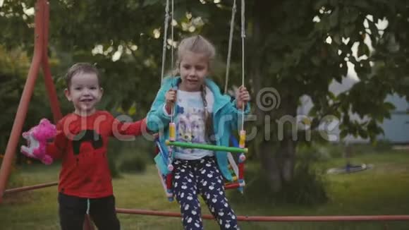 两个快乐的漂亮孩子牵着手在新鲜的空气中玩耍视频的预览图