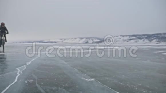 对轮胎的看法拍摄180fps人在冰上骑自行车骑自行车的人在镜头前割伤了冰的碎片视频的预览图