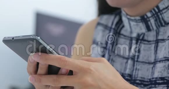 亚洲女人在家里用智能手机打短信视频的预览图