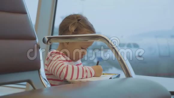 小女孩在机场画画背景是飞机视频的预览图