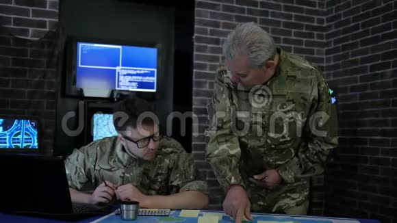 在简报时身着迷彩制服的指挥官和士兵在监测时视频的预览图