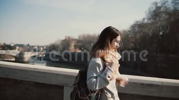 年轻有魅力的女性早上去上班美丽的女人在城市桥边散步喝咖啡视频的预览图
